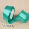 A roll of teal silk satin ribbon used for gift wrapping and craft projects.