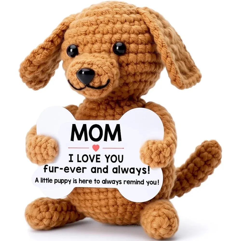 A handcrafted crochet dog doll in brown yarn with a white heart-shaped tag that reads I love you fur-ever and always
