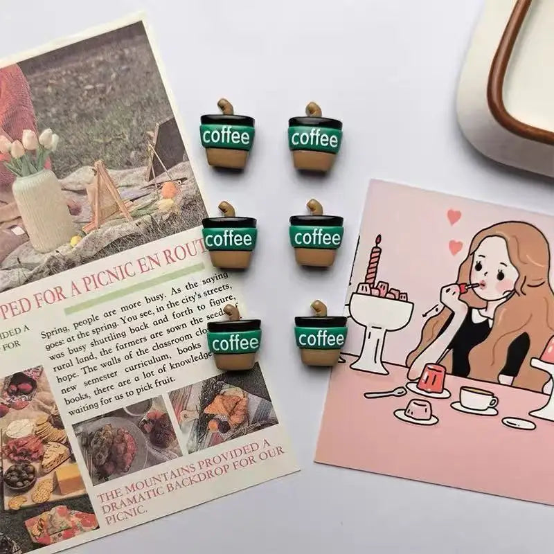 A set of green and brown coffee bean fridge magnets with a leaf shape displayed on a pink card.