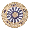 Round woven straw wall decor hanging with a white and gray geometric pattern