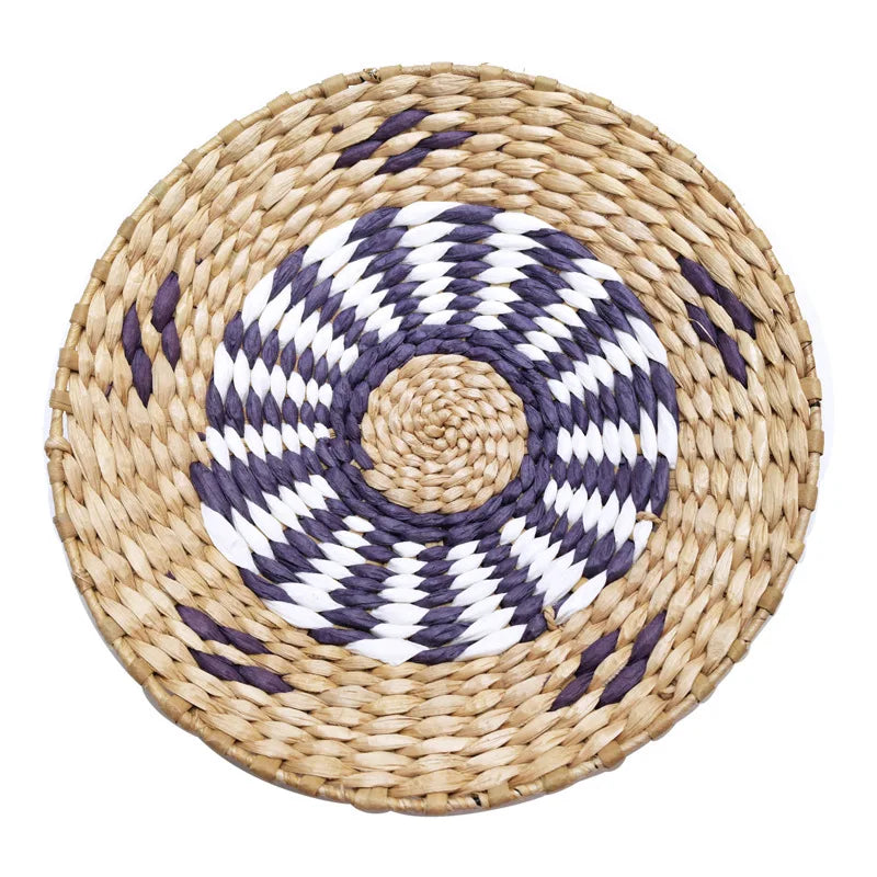 Round woven straw wall decor hanging with a white and gray geometric pattern