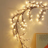 Willow branch string lights with remote control arranged in an arc against a light wall.