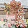 A pink and beige balloon garland arch kit featuring various sized balloons arranged in a floral design.