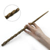 A hand holds a dark brown, twisted metal wand with a circular inset showing the texture.