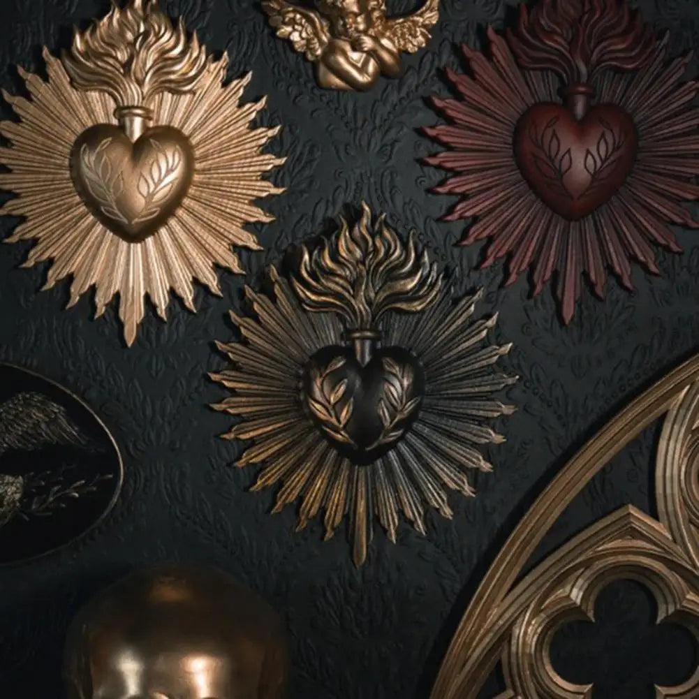 A collection of ornate gold and copper wall plaques featuring sacred heart designs with radiating sunburst patterns.