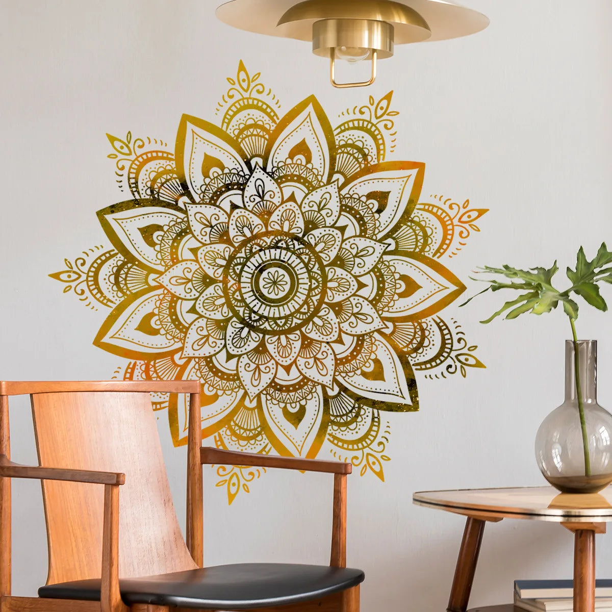 Un grand autocollant murale lotus mandala or et noir est exposé au-dessus d'une chaise et d'une table en bois.