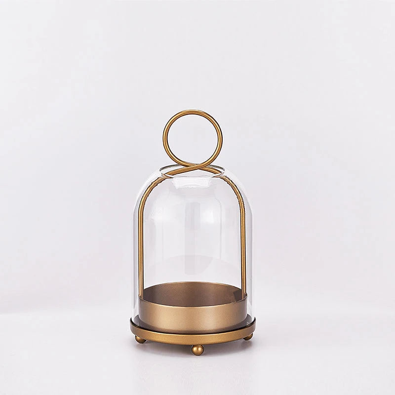 Antique brass metal candle holders with glass domes on a round base.