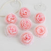 A collection of soft pink silk peony artificial flowers arranged on a white surface.