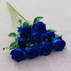 A bouquet of deep blue velvet artificial roses with green stems arranged on a light fabric.