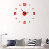 A round red digital wall clock with black hands and numbers is mounted on a white wall above a sofa.