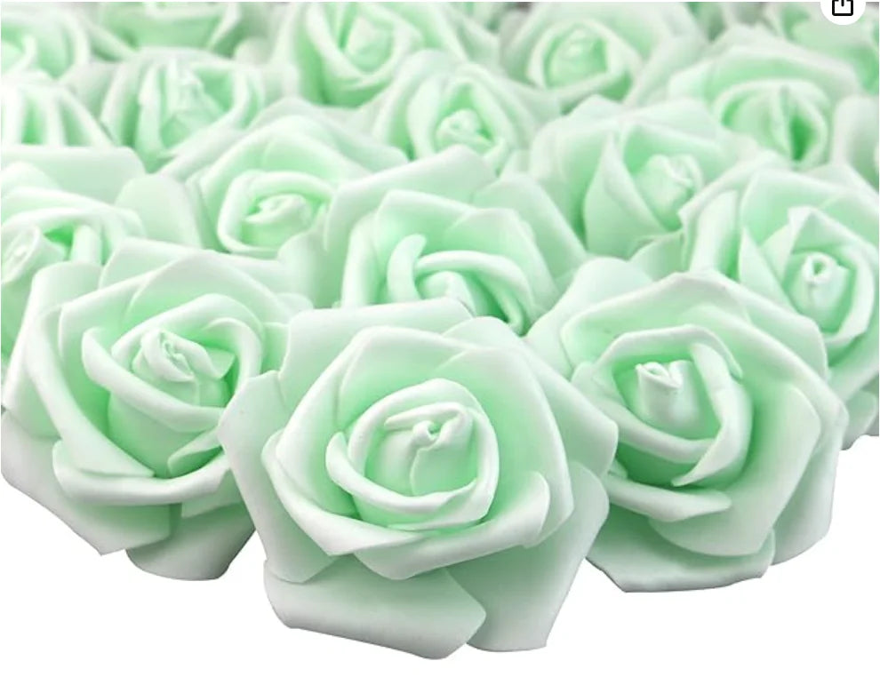 A close-up view of many light green artificial foam rose decorations arranged in a cluster.