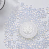 Clear wax sealing beads scattered on a white surface with a round silicone stamp in the center.