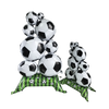 A stack of white and black soccer balls decorated with green ribbon, used as party decor.