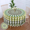Bohemian peacock mandala round tablecloth displayed on a wooden table with a chair in the background.
