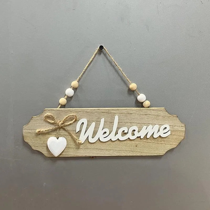 Rustic wooden welcome sign with the word Welcome carved into the wood and tied with twine.