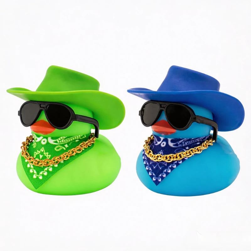 A green rubber duck shaped like a cowboy hat with black sunglasses and gold chain, next to a blue rubber duck with a blue ban
