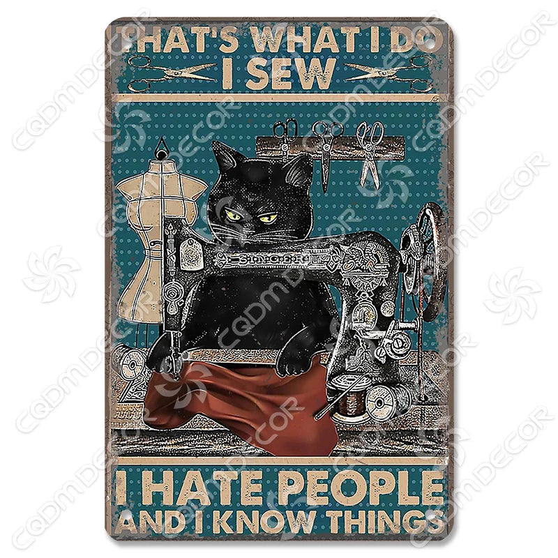 Décor mural vintage en métal représentant un chat noir cousant avec fil et outils, sur fond bleu sarcelle.