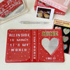 A red multi-size photo album titled Mine with a heart design, next to other photo albums and a pencil.