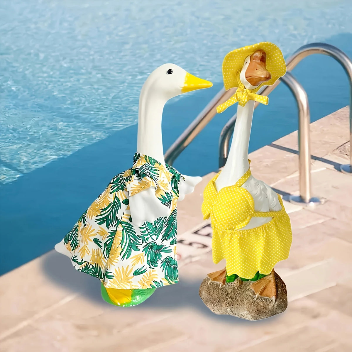 A white goose costume set with yellow polka-dot fabric and a straw hat standing on a stone ledge by blue water.
