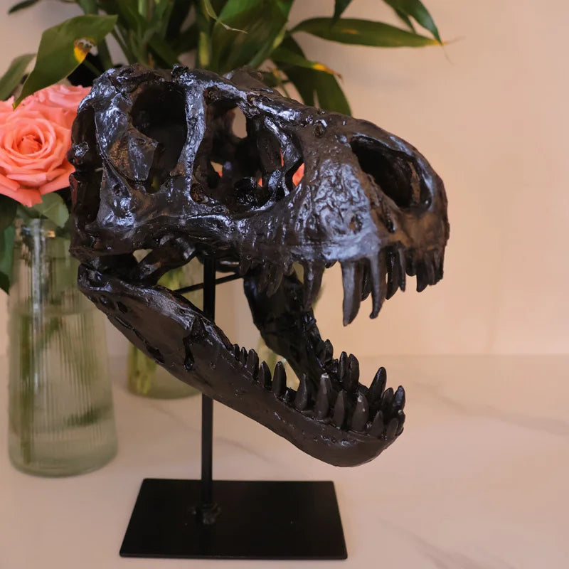 A dark resin sculpture of a realistic dinosaur skull displayed on a black stand.