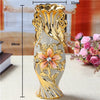 Gold-plated ceramic tabletop vase with ornate scrollwork and a central pink flower design.