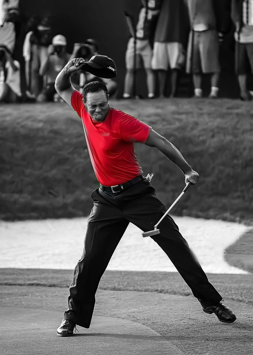 A man in a red shirt is swinging a golf club on a golf course, with spectators blurred in the background.