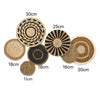 A collection of round boho straw wall hangings with varying diameters and shades of natural woven fibers.