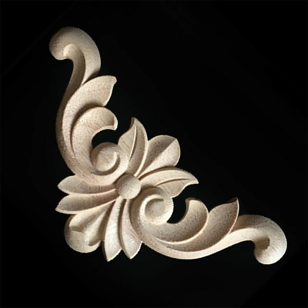 A set of four light-colored wooden carved corner appliques used for furniture and frame decoration.
