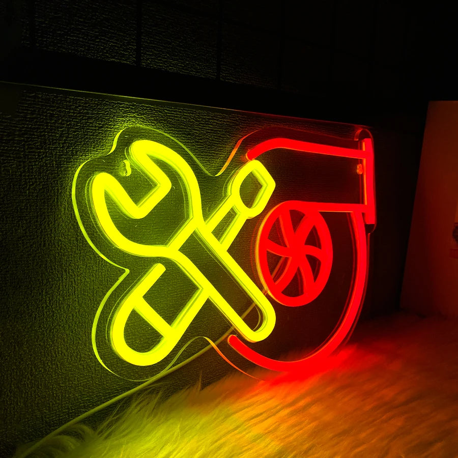 A neon sign featuring a yellow wrench and screwdriver crossed over a red and orange background.