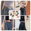 Close-up of pearl butterfly waist tightener buttons for jeans on a model's denim outfit.