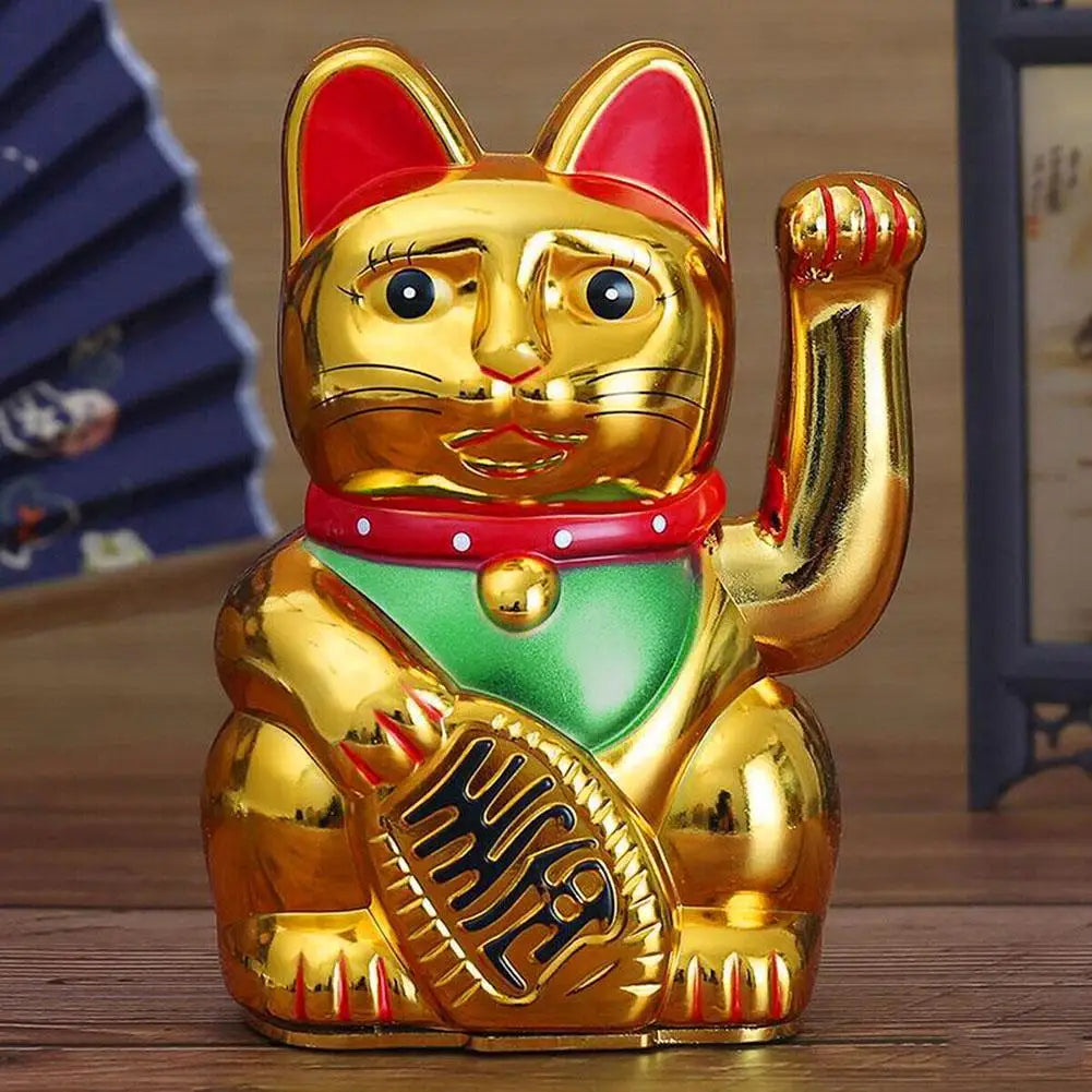 A golden animated electric fortune cat decor figurine sitting on a wooden surface.