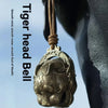 A close-up of a pure copper tiger head bell hanging, used for Feng Shui decor.