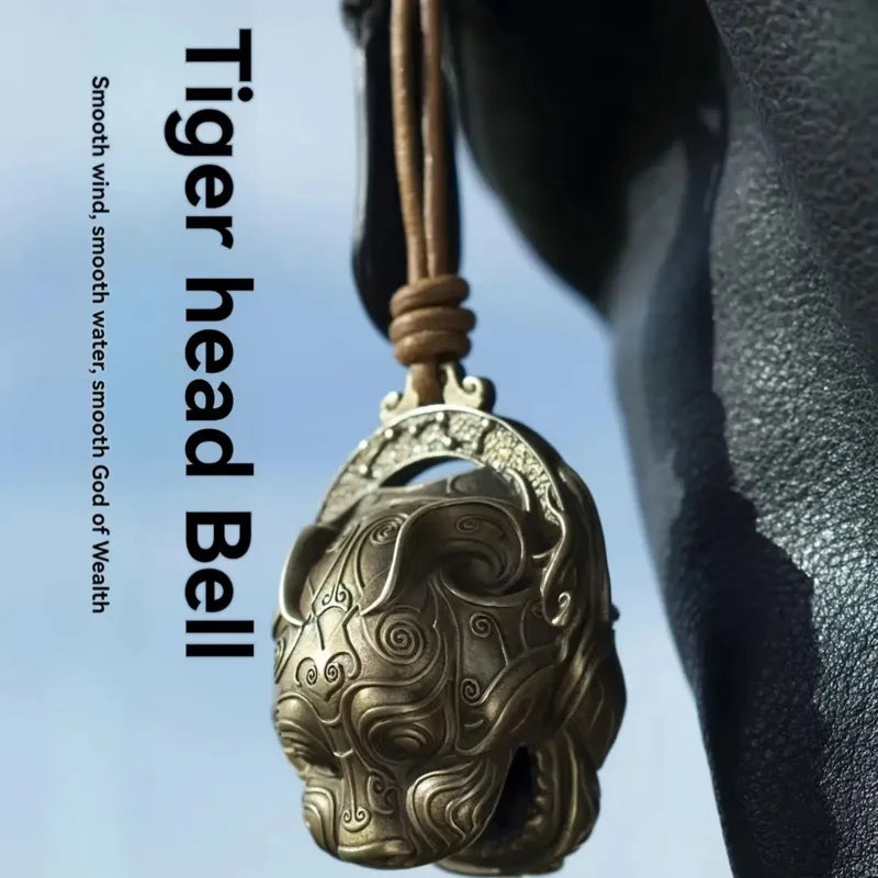 A close-up of a pure copper tiger head bell hanging, used for Feng Shui decor.