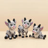 Three gray goat figurines with pink noses and black horns are displayed on a light background.