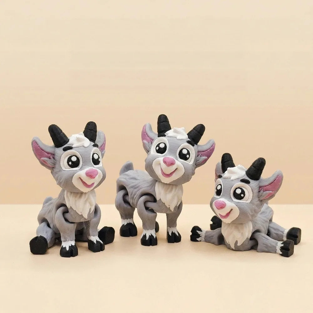 Three gray goat figurines with pink noses and black horns are displayed on a light background.