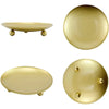 A set of elegant gold iron candle holder trays, including a shallow oval tray and a round plate with decorative studs.