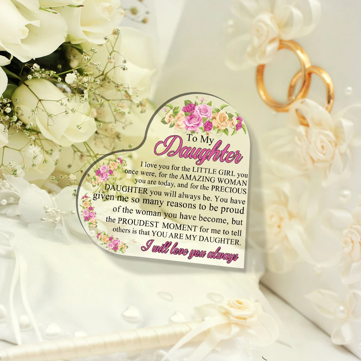 Herzförmige Acrylplakette mit 'Für meine Tochter', umgeben von weißen Rosen und goldenen Ringen.