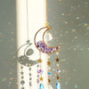 A handcrafted gold pendant featuring a purple moon crystal and dangling prism charms.