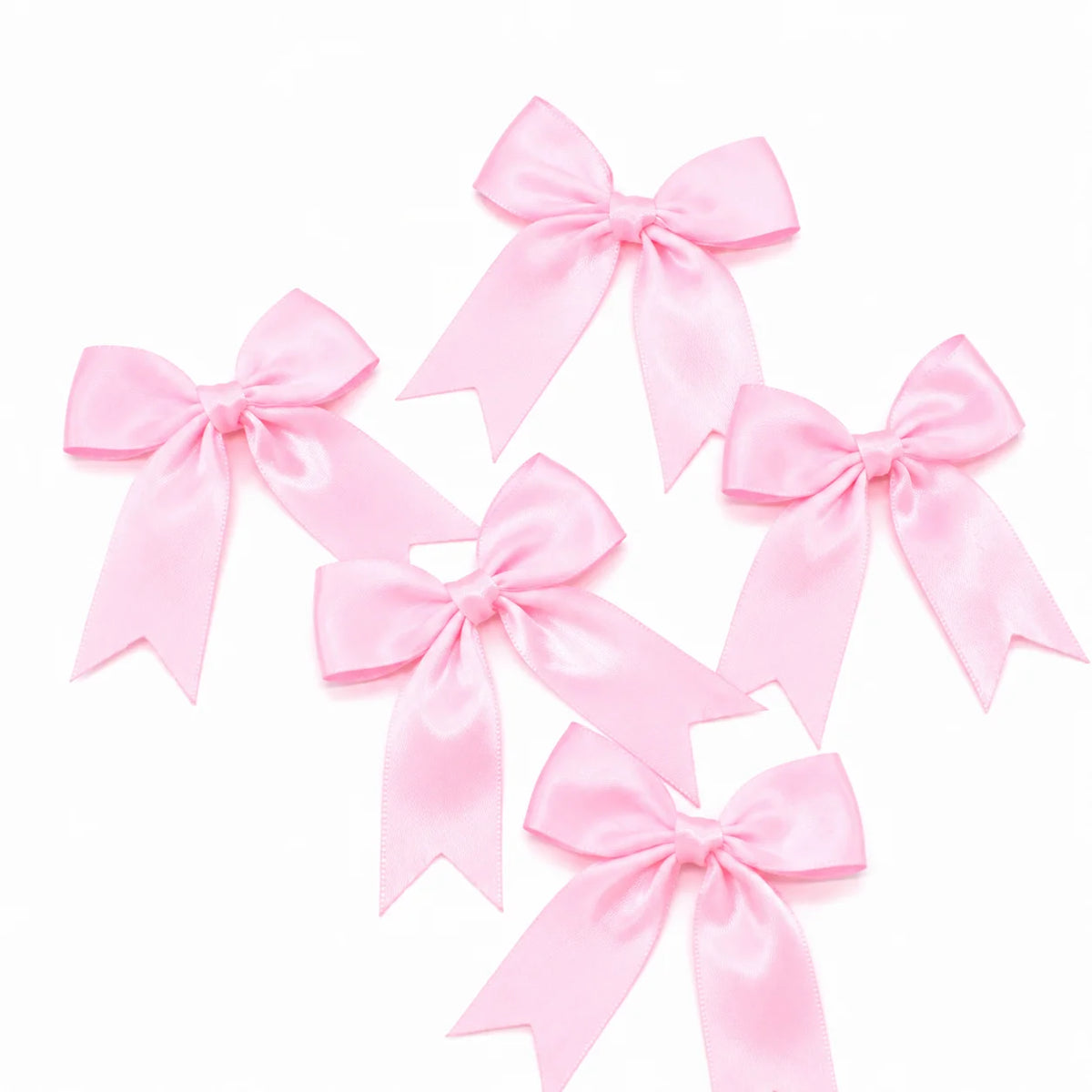 Pink satin ribbon bows arranged on a white background for gifts and crafts