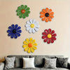 A collection of colorful iron sunflower wall art decor in various shades of orange, yellow, green, and blue mounted on a beig