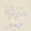 A white LED neon sign shaped like the words Hello Gorgeous with a USB power cord.