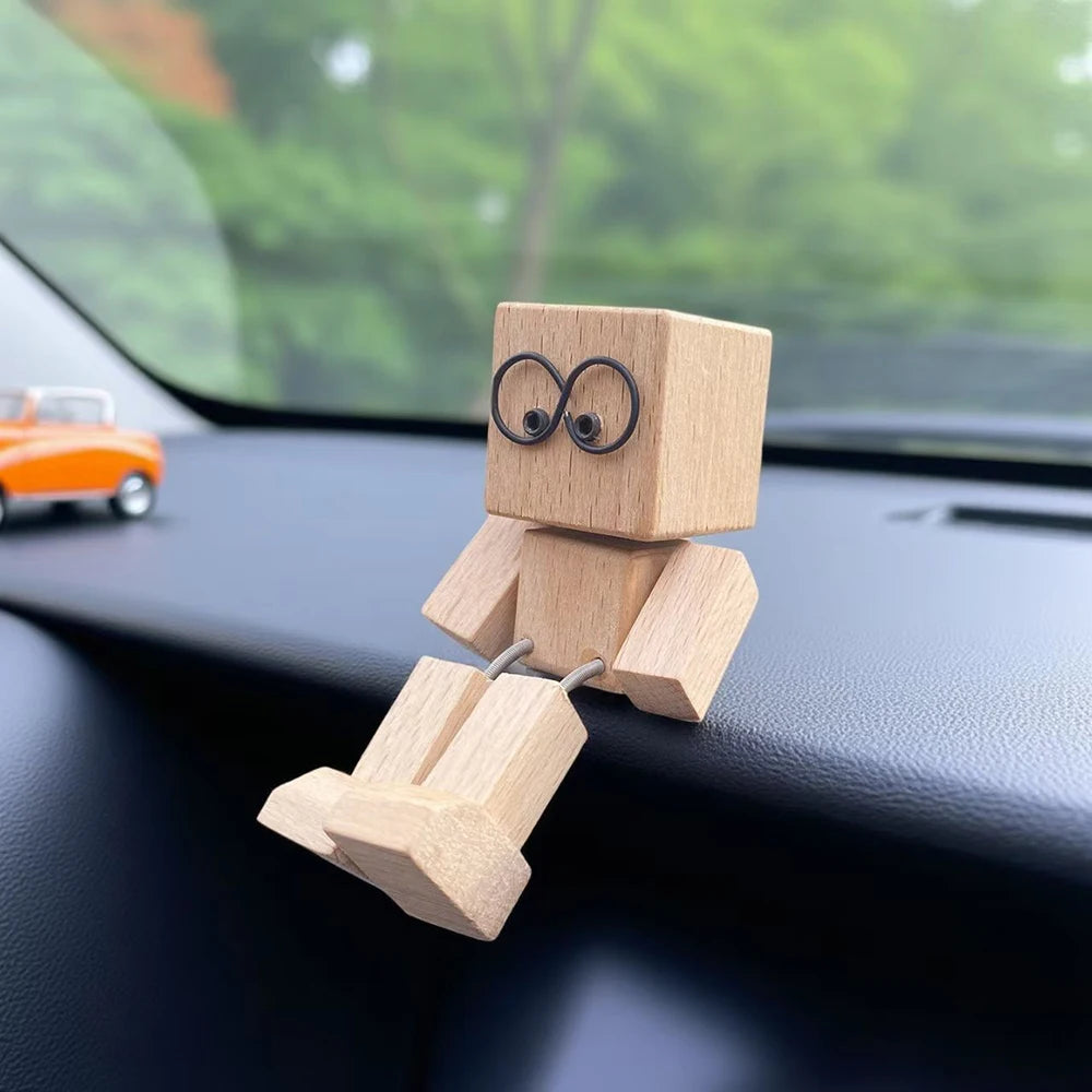 Petine figurine en bois avec un symbole infini sur la poitrine, posée dans l'intérieur sombre d'une voiture.