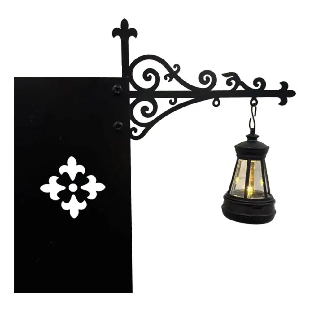 Black wrought iron wall sconce lamp with a glass shade and soft warm glow