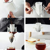 Hands are shown using disposable hanging ear coffee filter bags for pour-over brewing into a glass.