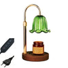 A brass and green glass aromatherapy candle warmer lamp with an adjustable height stand and a wooden base.