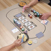 A person is using reusable wheat straw finger chopsticks to pick up snacks on a game mat.