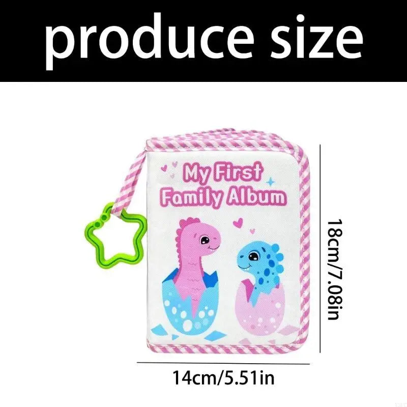 A pink cloth baby photo album with a green cord and a dinosaur design.