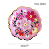 Eight pink floral disposable plates with red and green accents.
