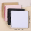 A stack of spiral-bound paper notebooks in pink, black, and beige tones.