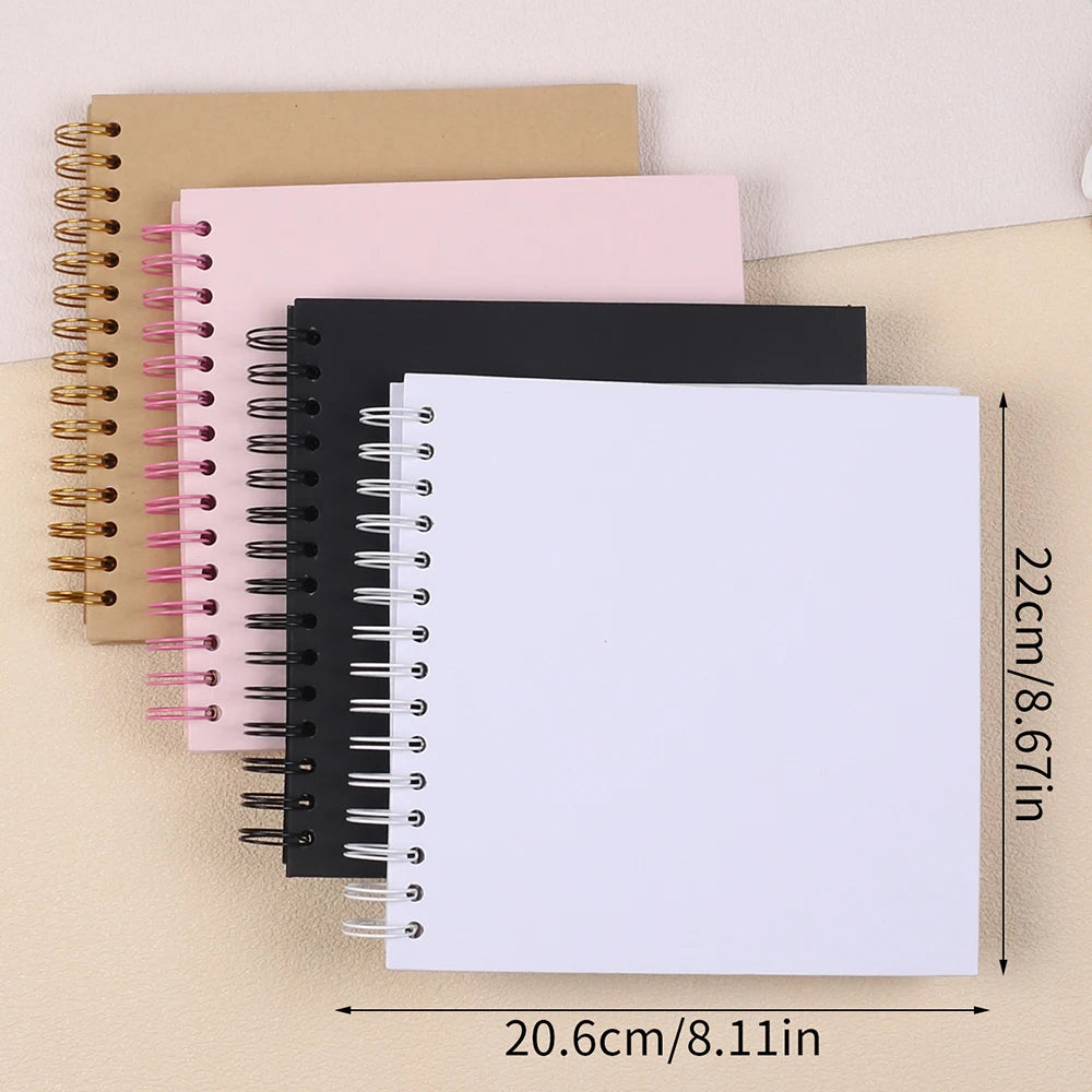 A stack of spiral-bound paper notebooks in pink, black, and beige tones.